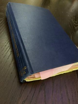 The book with pink and yellow notes protruding
